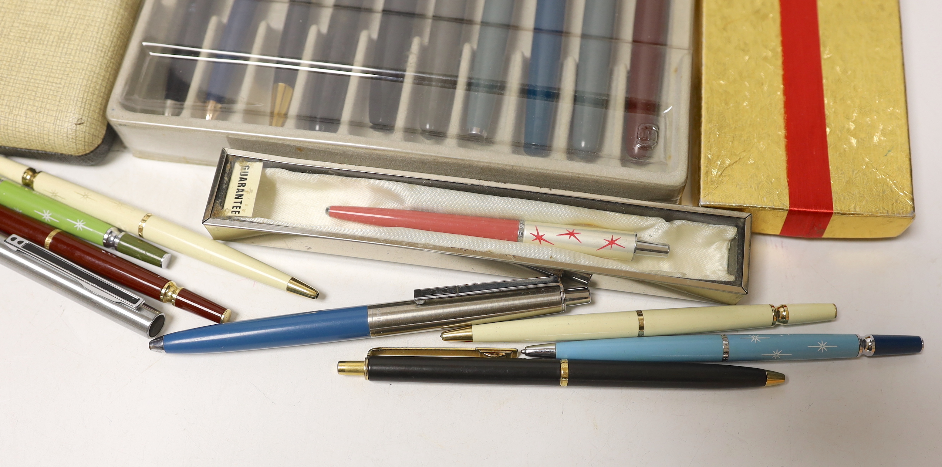 A collection of pens including Parker and pen-related publications